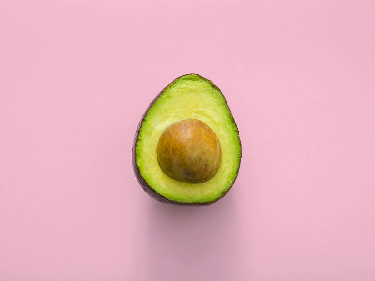 Fresh avocado on a pink background